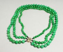 A GOOD SET OF JADE BEADS with gold clasp.