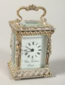 A CHARLES FRODSHAM SILVER CASED MINIATURE CLOCK, the case with caryatid figures, carrying handles on
