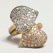 A 9CT GOLD DIAMOND CROSS OVER HEART SHAPED RING.
