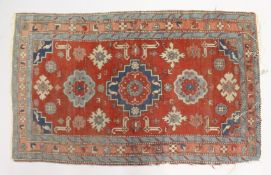 A SMALL PERSIAN RUG, red ground with geometric decoration. 4ft 2ins x 2ft 7ins