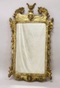A GOOD GEORGE III DESIGN CARVED WOOD AND GILDED MIRROR with acanthus scrolls, masks and urns. 3ft