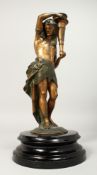 A PAINTED BRONZE FIGURE OF AN EGYPTIAN MAN holding a torch. 11ins high on a circular marble base.