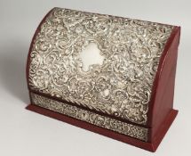 A SILVER EMBOSSED STATIONARY BOX, opening to reveal a fitted interior. Maker, M & LS 11ins wide.