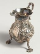 A GEORGE II CREAM JUG with repousse decoration. London 1751