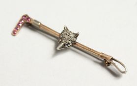A GOLD AND DIAMOND HUNTING-THEMED BAR BROOCH as a riding crop mounted with a fox's head.