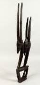 A CARVED WOOD TRIBAL FIGURE OF ANTELOPES. 31ins long.