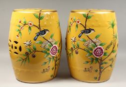 A PAIR OF CHINESE YELLOW POTTERY BARREL SEATS painted with birds and flowers. 17ins high.