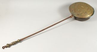 A 17TH - 18TH CENTURY DUTCH BRASS CIRCULAR WARMING PAN with metal handle. 42ins long.
