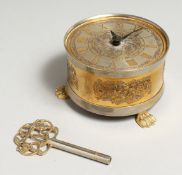 A SINCLAIRE HARDING CIRCULAR TABLE CLOCK with engraved dial on three claw feet. 4ins diameter, 2.