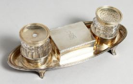 A GEORGE III BOAT SHAPED TWO BOTTLE INKSTAND, the centre with a box with rising lid. 7.5ins long.