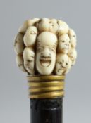 A ROSEWOOD WALKING CANE WITH JAPANESE CARVED IVORY HANDLE depicting 18 Noh masks. 35ins long.