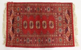A SMALL BOKHARA RUG, with a single row of five medallions. 3ft 3ins x 2ft 2ins.