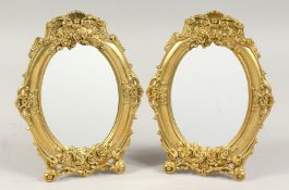 A PAIR OF GILDED METAL OVAL MIRRORS. 9ins long.