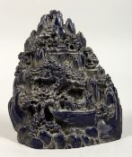A CHINESE CARVED FAUX-LAPIS BOULDER, trees, figures, and boats. 7ins high.