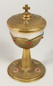 A GOOD EUROPEAN BRASS COMMUNION CHALICE AND COVER set with beads, the lid with a cross. 7.5ins