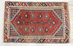 A SMALL PERSIAN RUG, red ground with geometric decoration. 4ft x 2ft 6ins.