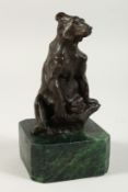 A SMALL BRONZE OF A SEATED BEAR on a marble base. 5ins high.