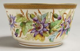 A ROYAL WORCESTER BOWL painted with a gilt and black border painted with passion flowers.