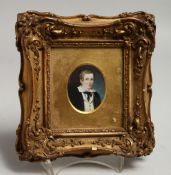 A FRAMED MINIATURE PORTRAIT OF A SCHOOL BOY in a moulded gilt frame.