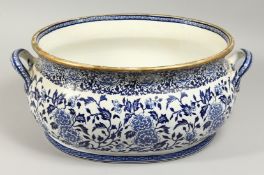 A LARGE VICTORIAN BLUE AND WHITE OVAL FOOT BATH with handles. 18ins long