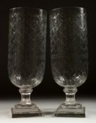 A PAIR OF SHELL CUT GLASS STORM LAMPS on stepped square bases. 16ins high.