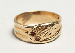 A 9CT GOLD SNAKE RING set with ruby eyes