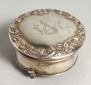A CIRCULAR SILVER BOX on three curving feet, 3ins diameter. Birmingham, 1909.