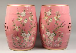 A PAIR OF CHINESE PINK POTTERY BARREL SEATS painted with birds and flowers. 17ins high.