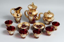 A CONTINENTAL GLASS GILT AND ENAMEL PAINTED TEA SET comprising tea pot, sugar bowl, milk jug and six