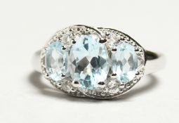 A SILVER THREE STONE TOPAZ RING.