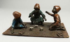 A VIENNA BRONZE GROUP, THREE BOYS PLAYING DICE. 19cm wide.