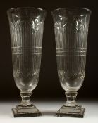 A GOOD PAIR OF CUT GLASS TAPERING VASES on stepped square bases. 17ins high.