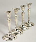 A SET OF FOUR OVAL SILVER CANDLESTICKS on loaded bases. 7.5ins high, Sheffield, 1907.
