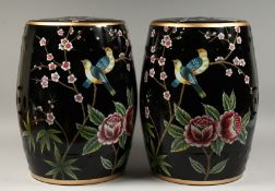 A PAIR OF CHINESE BLACK POTTERY BARREL SEATS painted with birds and flowers. 17ins high.