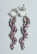 A PAIR OF RUBY AND MOTHER OF SNAKE PEARL EARRINGS.