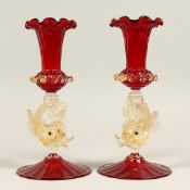 A PAIR OF VENETIAN RUBY TINTED GLASS VASES with dolphin stems. 9.5ins high.