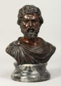 A GOOD CLASSICAL BRONZE BUST of a man. Signed, 7.5ins high, on a circular base.