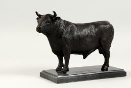 A BRONZE STANDING BULL on a marble base. 9ins long.