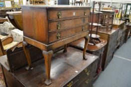 A walnut three drawer chest on cabriole legs.