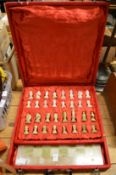 An onyx chessboard and chess pieces housed in a velvet box.