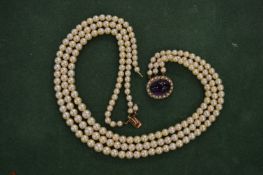 A pearl choker with yellow metal clasp, stamped 14ct, mounted with a cabochon amethyst and seed
