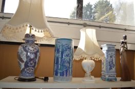 A large vase shaped lamp, a stick stand and other items.