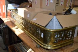 A pierced brass fender and three wall lights.