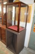 A glass display cabinet on painted base.