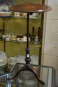 A mahogany tripod table with adjustable top.