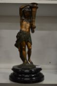A spelter lamp base modelled as an Egyptian man holding a torch.