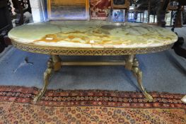 An onyx and brass oval coffee table.