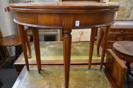 A demi-lune foldover table with two extension leaves.