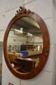 An oval mirror with decorative mount.