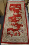 A Chinese red ground pictorial rug.